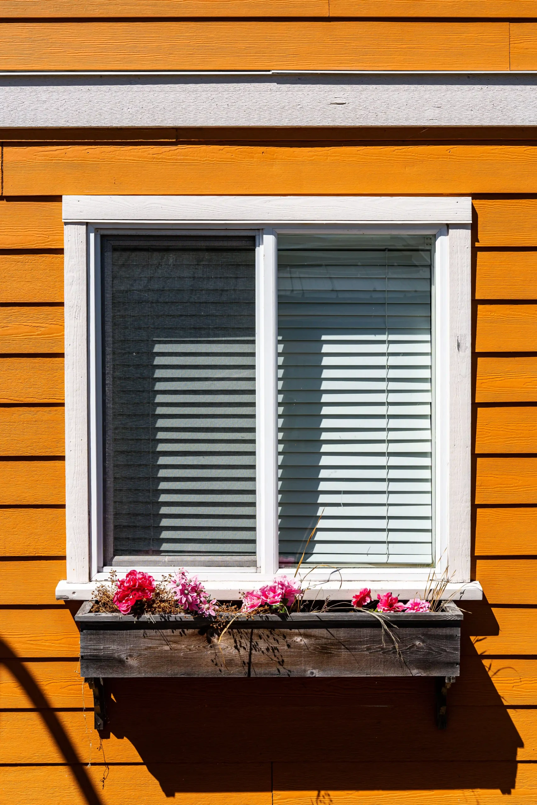 vinyl window with flower pots on an orange house