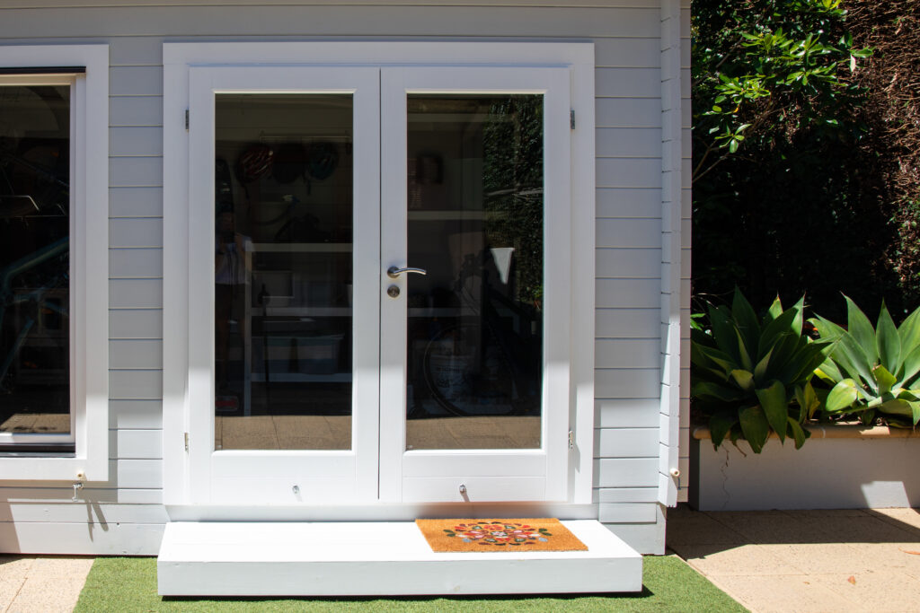 A recently installed glass door leading out into a backyard.